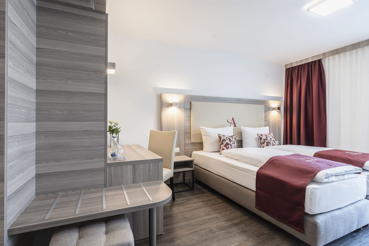 Ett modernt hotellrum med en säng, ett skrivbord och en stol.