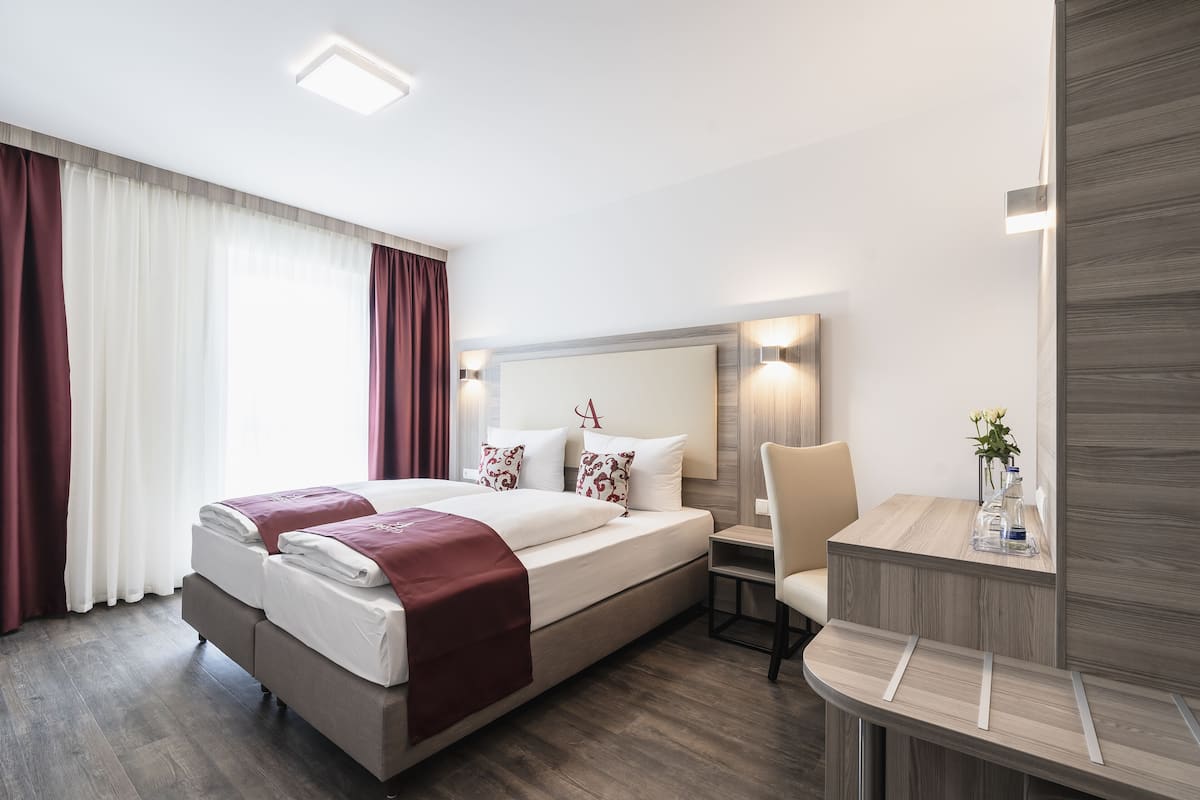 Ett modernt hotellrum med en stor säng, ett skrivbord och en stol.