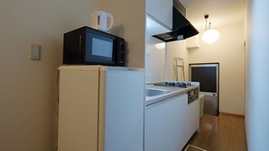 A compact kitchen with a refrigerator, microwave, and stove. - Kyo Maimai (Kyoto)