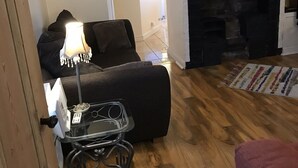 A living room with a fireplace, a sofa, a lamp, and a small table with a tray.
