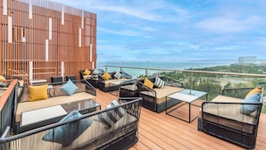 Une terrasse sur le toit, avec des sièges en plein air, une clôture en bois et une vue sur le paysage urbain.