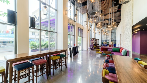 Un espacio interior amplio con techos altos, ventanas grandes y luminarias modernas.