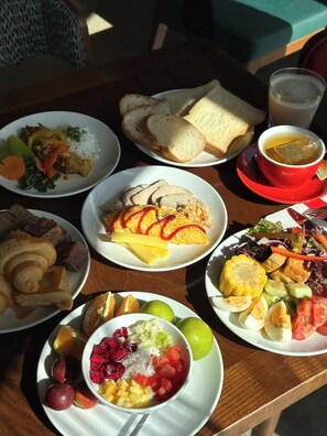 A table with various food items including sandwiches, a bowl of fruit, and a cup of tea.