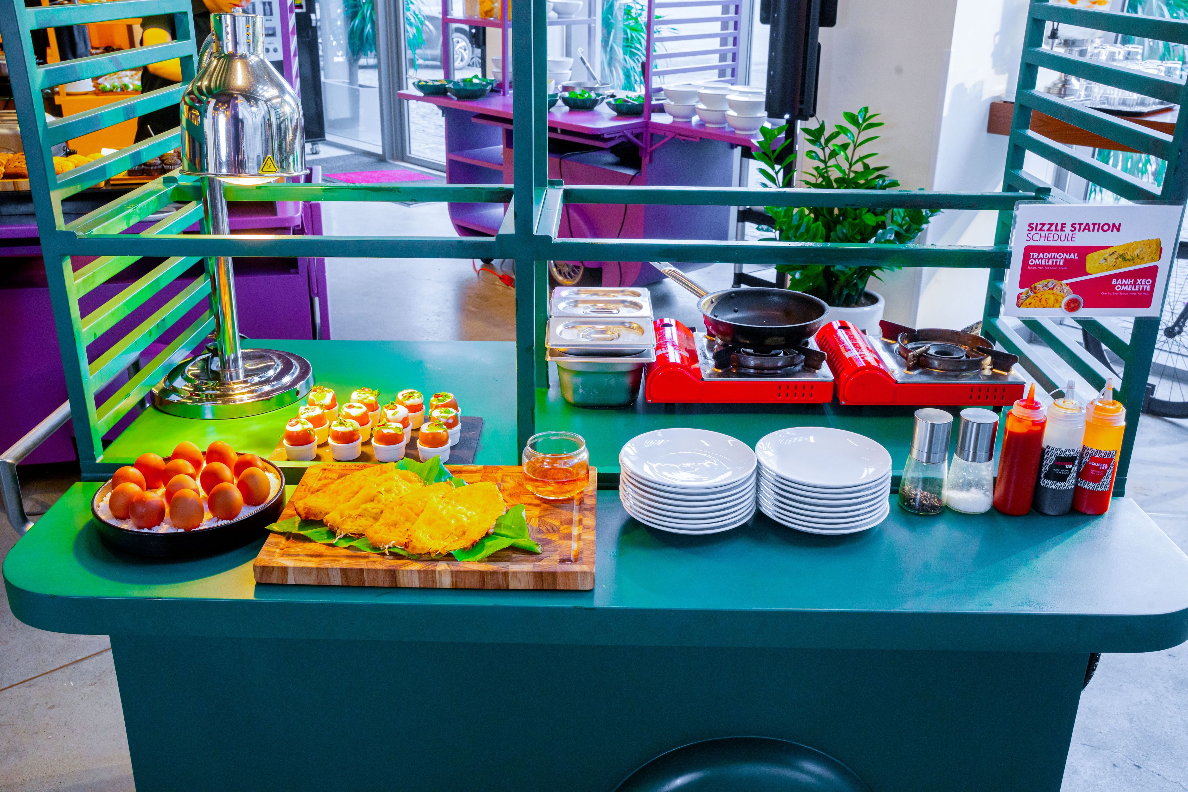 Un puesto de comida con distintos platos, salsas y una estación de cocina a la parrilla.