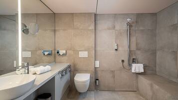 Ein modernes Badezimmer mit großem Waschbecken, Toilette und Dusche.