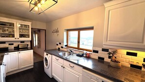 A modern kitchen with white cabinets, a built-in washing machine, and a dishwasher.