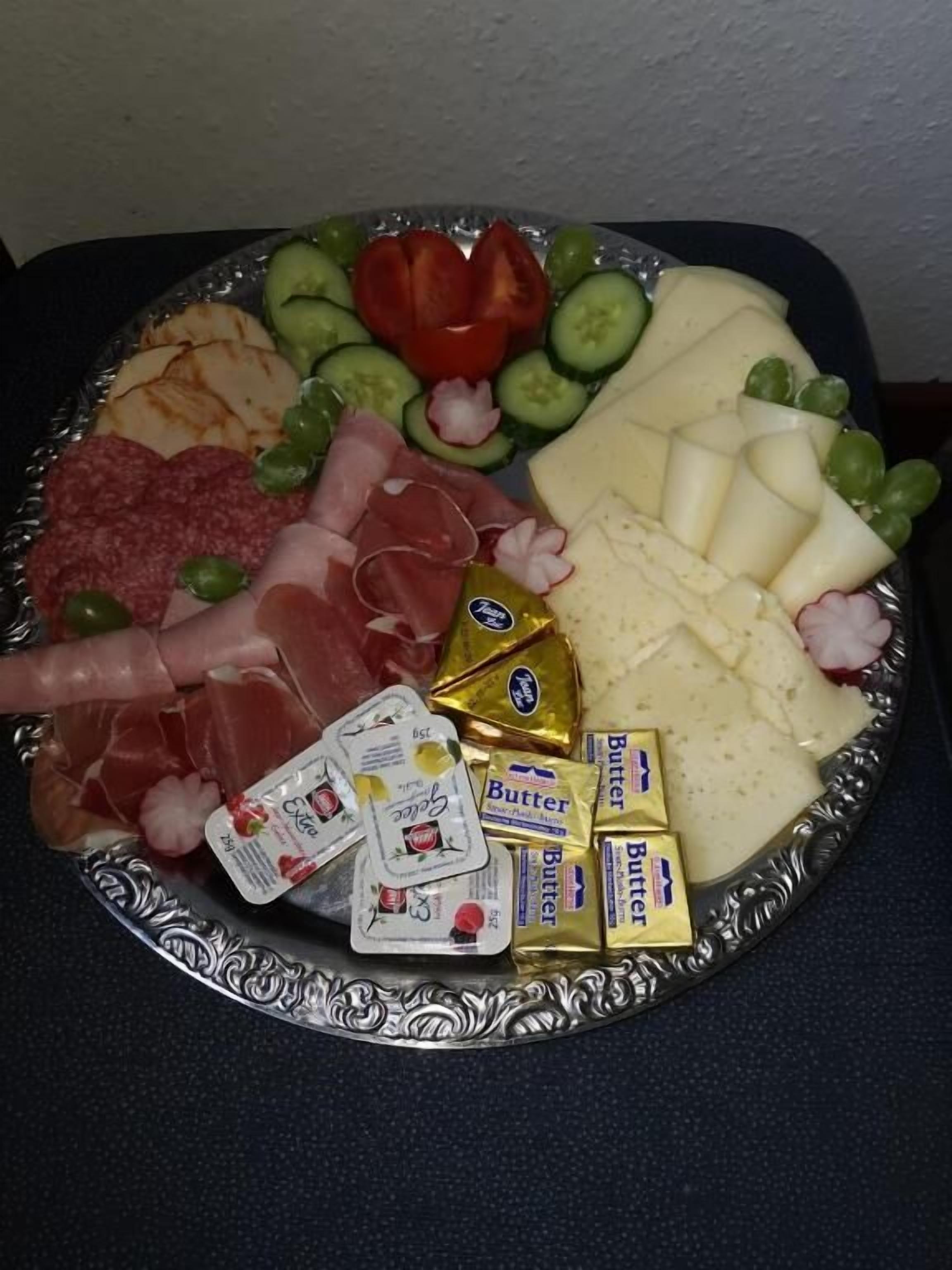 Eine Platte mit verschiedenen Käsesorten, Fleisch und Gemüse.