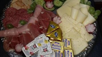 Eine Platte mit verschiedenen Käsesorten, Fleisch und Gemüse.
