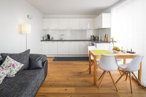 A compact living space with a kitchenette, a dining area, and a sofa.