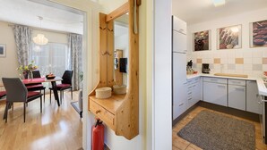 Eine moderne Küche mit einer Holztischinsel, einem Essbereich mit Tisch und Stühlen sowie einem sichtbaren Feuerlöscher.