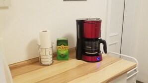 A kitchenette with a coffee maker, a roll of paper towels, and a coffee cup on the wall. - Quietly located vacation apartment in Pfronten (Pfronten)