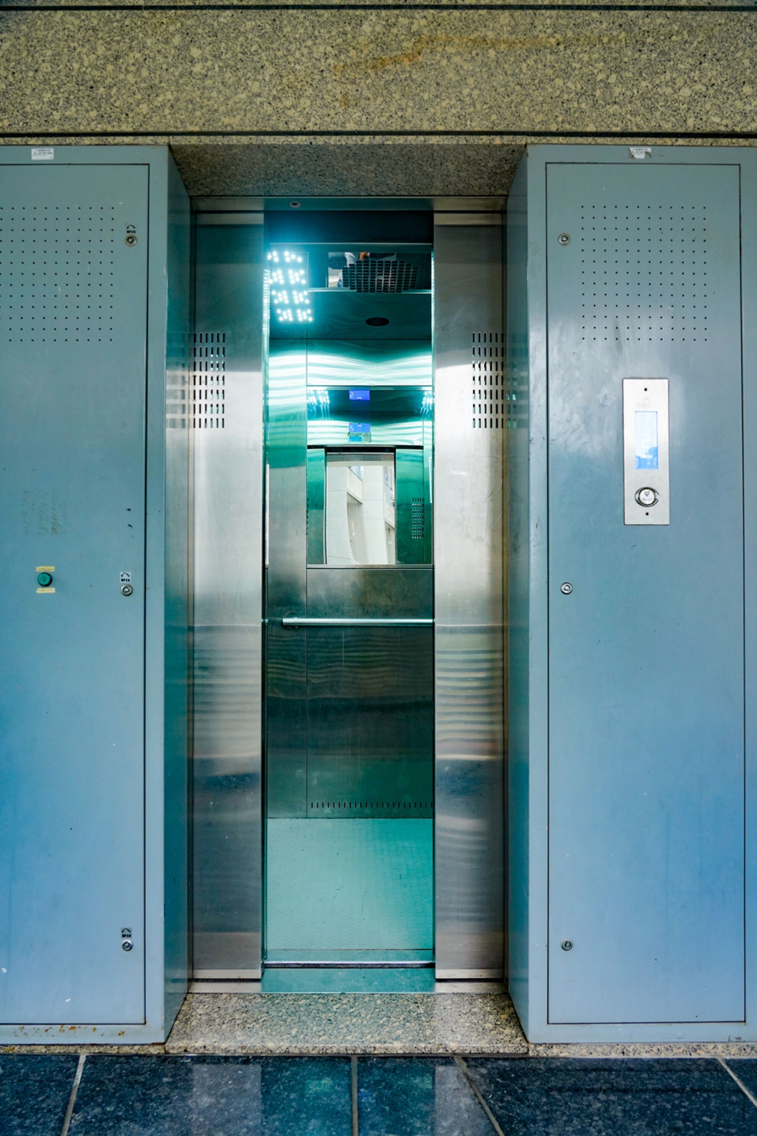 An elevator with metallic doors and a control panel on the right side.
