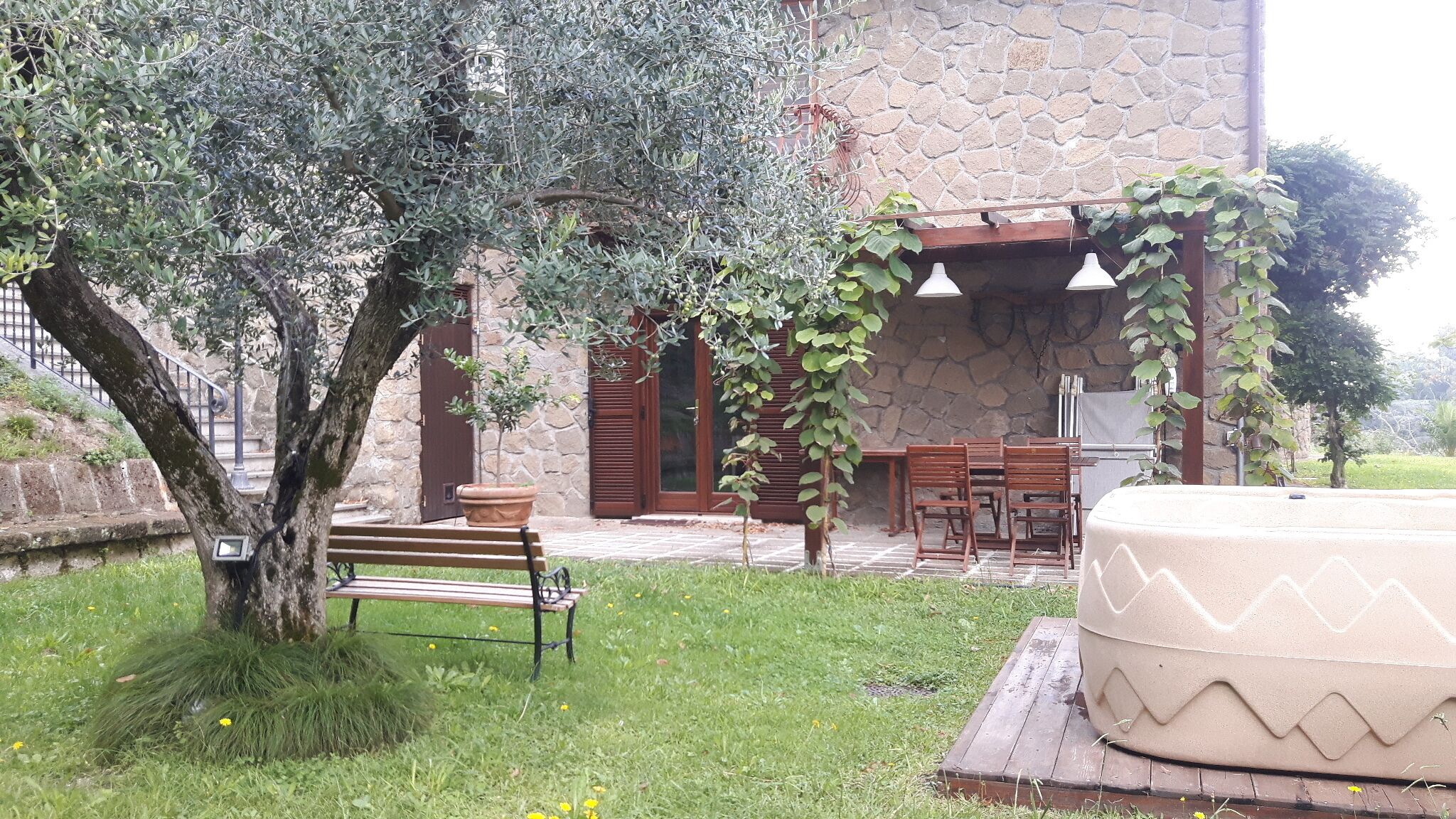 A stone building with a patio area, outdoor seating, and a large planter.