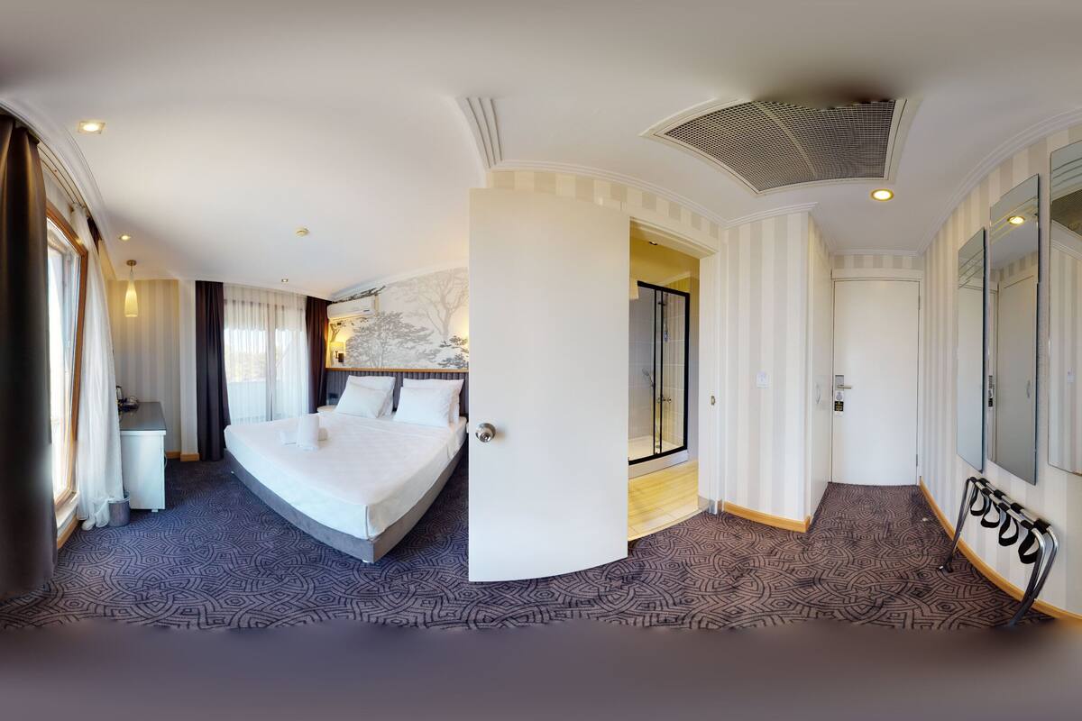 Une chambre d’hôtel avec un grand lit, un bureau, une douche et une vue sur la ville.