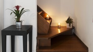 A staircase with a wooden finish, a black metal handrail, and a small table with a potted plant. - Hotel del Porto (Torri del Benaco)
