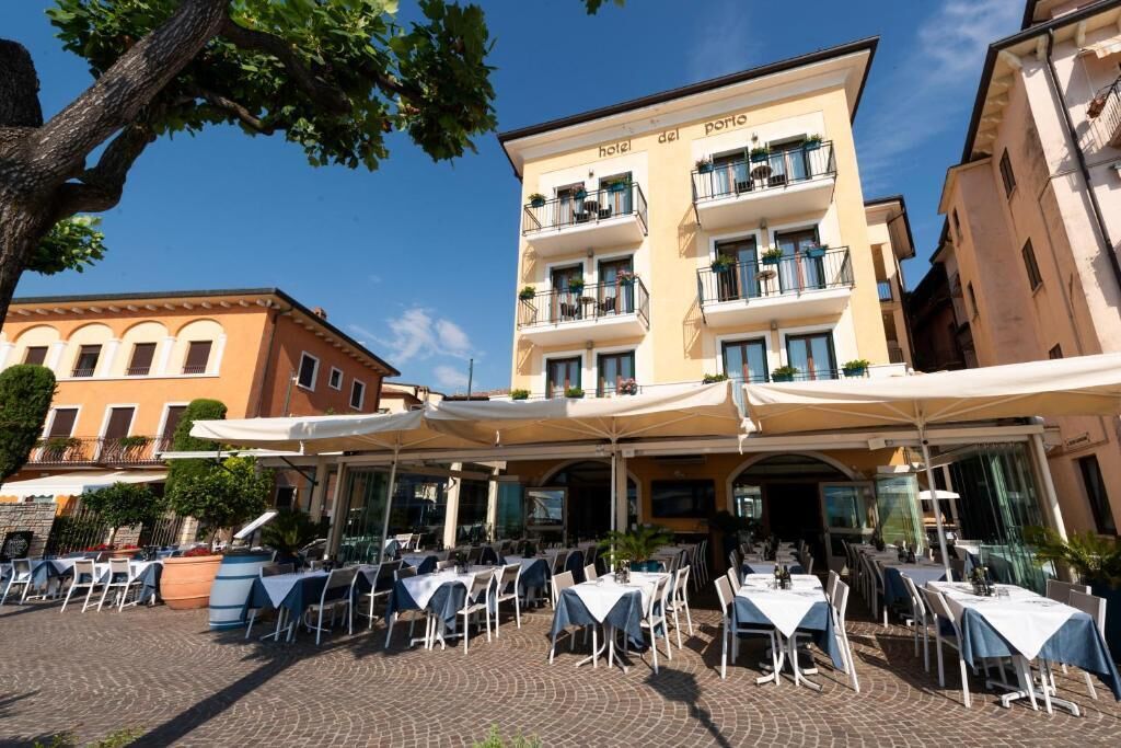 A hotel with outdoor seating, a multi-story building, and a clear sky.