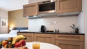 A modern kitchen with wooden cabinets, a microwave, and a coffee maker on the counter. - Five Resort Cholet Centre (Cholet)