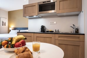 A modern kitchen with wooden cabinets, a microwave, and a coffee maker on the counter.
