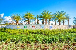 Surrounded by lush greenery, this tranquil oasis features a low wall adorned with icons highlighting the property's amenities.