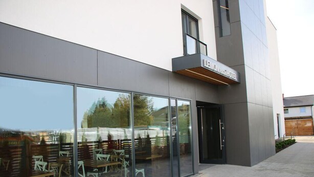 A modern hotel exterior with large glass windows reflecting outdoor scenery. - Lemon Plaza Poznań (Poznan)