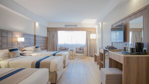 A hotel room with two beds, a desk, a chair, a small table, and a large mirror. - Season Star Hotel (Madinah)