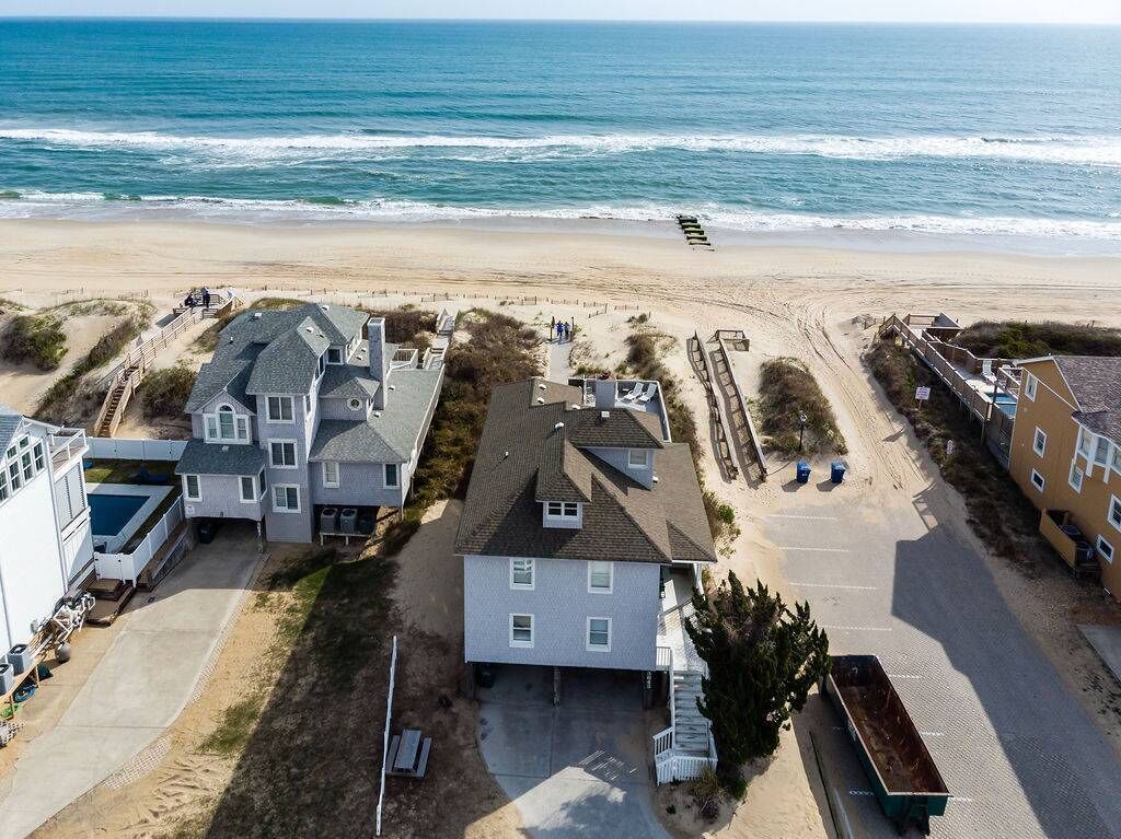 Zona residencial costera con casas, una playa y un muelle.