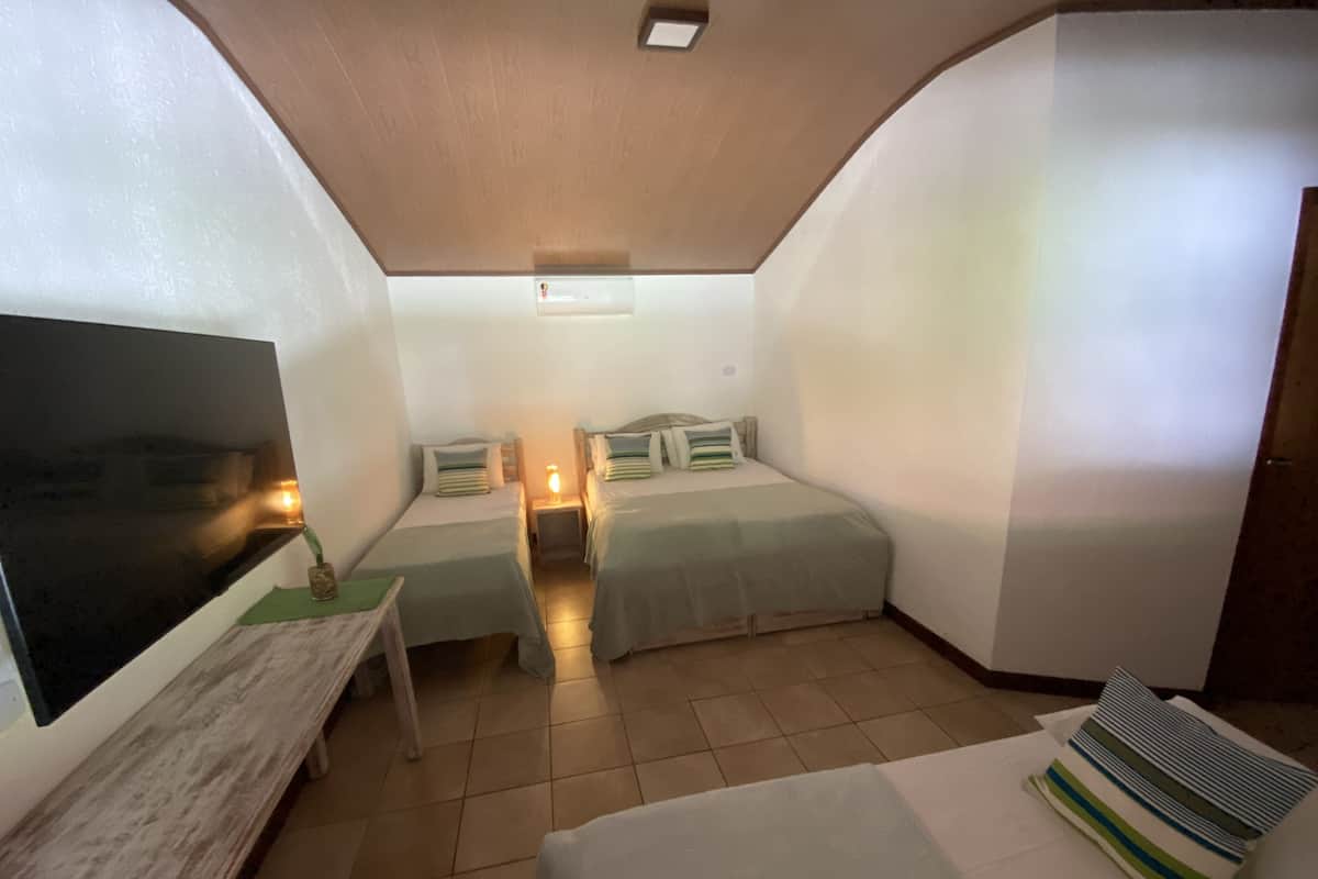 A small, cozy room with two single beds, a desk, and a TV.
