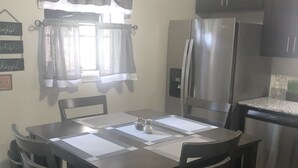 Een eethoek met een vloerkleed met zebraprint, een tafel met placematen en stoelen.