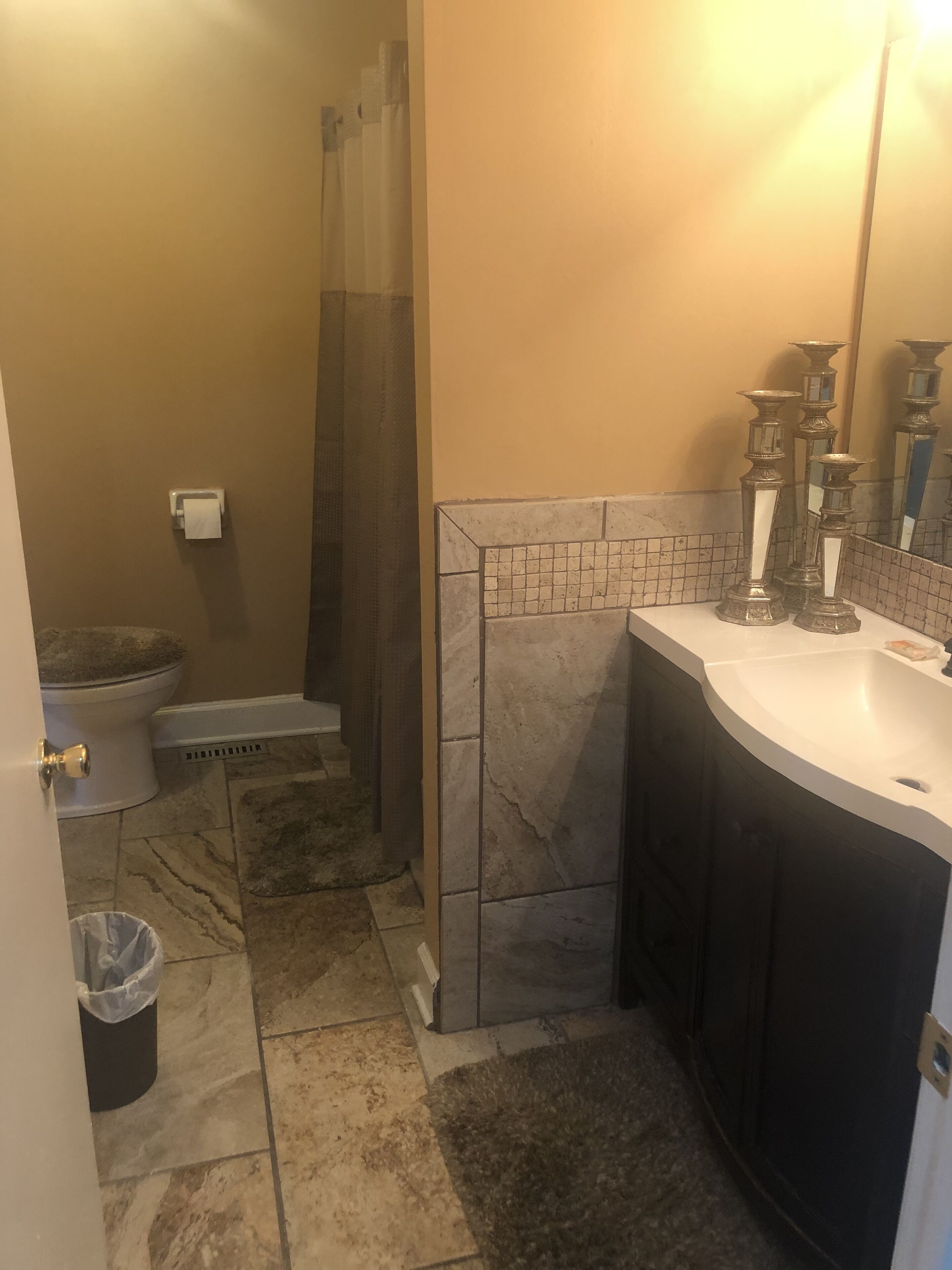 A bathroom with a shower, toilet, and sink.