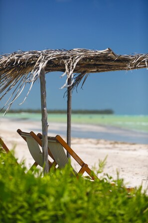 På stranden, vit sandstrand, solstolar och parasoller