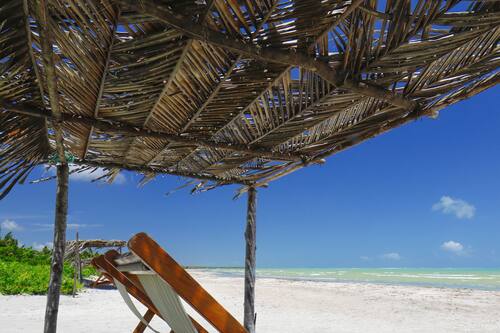 En la playa, playa de arena blanca, camastros y sombrillas