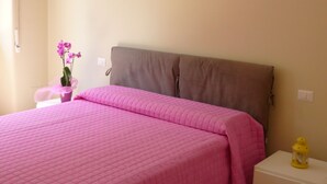 A bedroom with a bed, a nightstand, a lamp, and a potted plant. - Renovated apartment 3 floor with elevator in Prati (Roma)