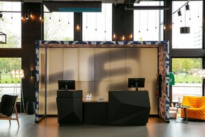 A modern reception area with a digital display wall, a reception desk, and seating. - Aloft by Marriott Strasbourg City Centre (Strasbourg)