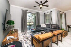 Relax in this stylish living room with a sofa, ottoman, and flat-screen TV.