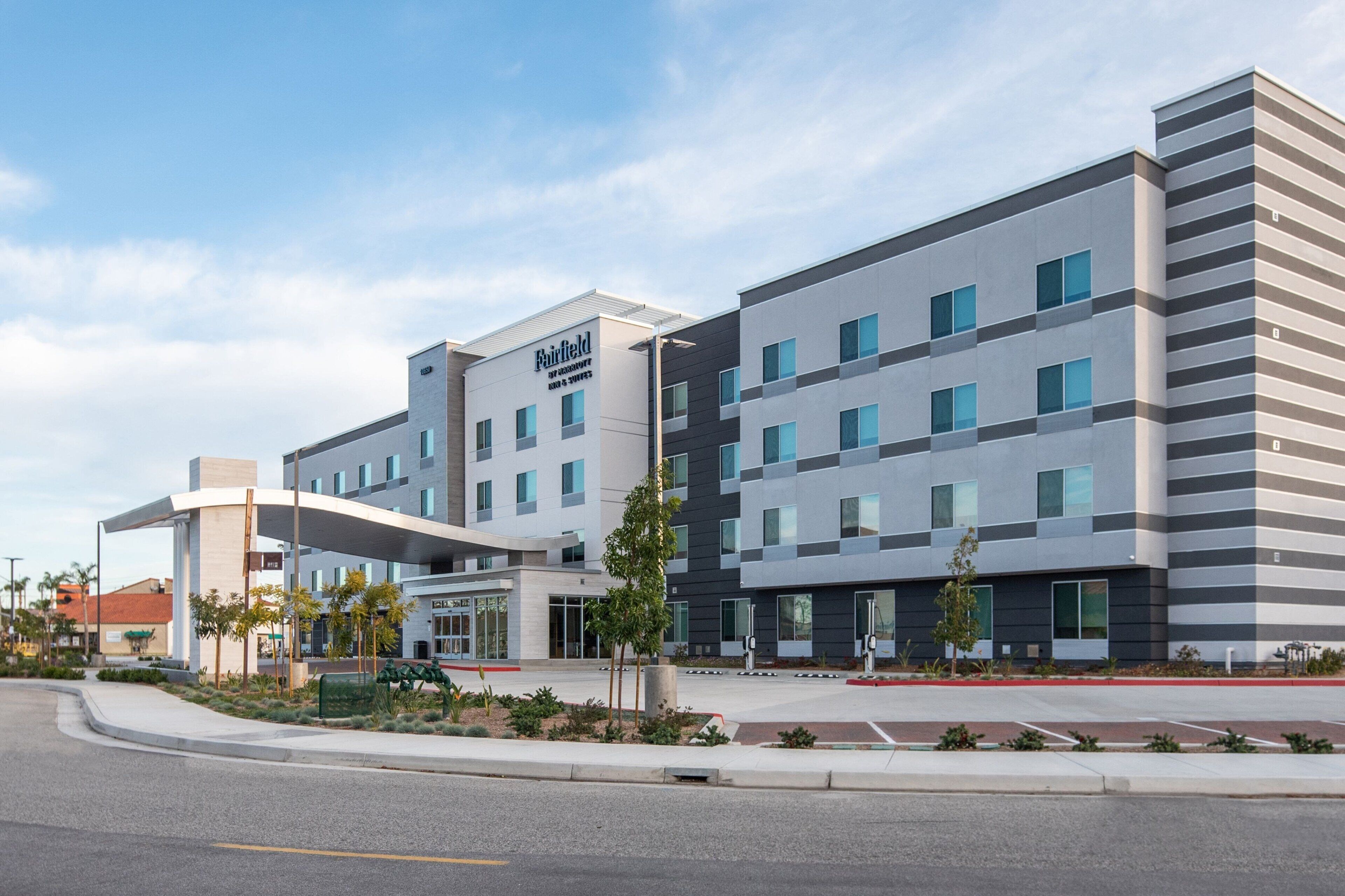A modern hotel with a flat roof, multiple floors, and a sign reading "Fairfield."
