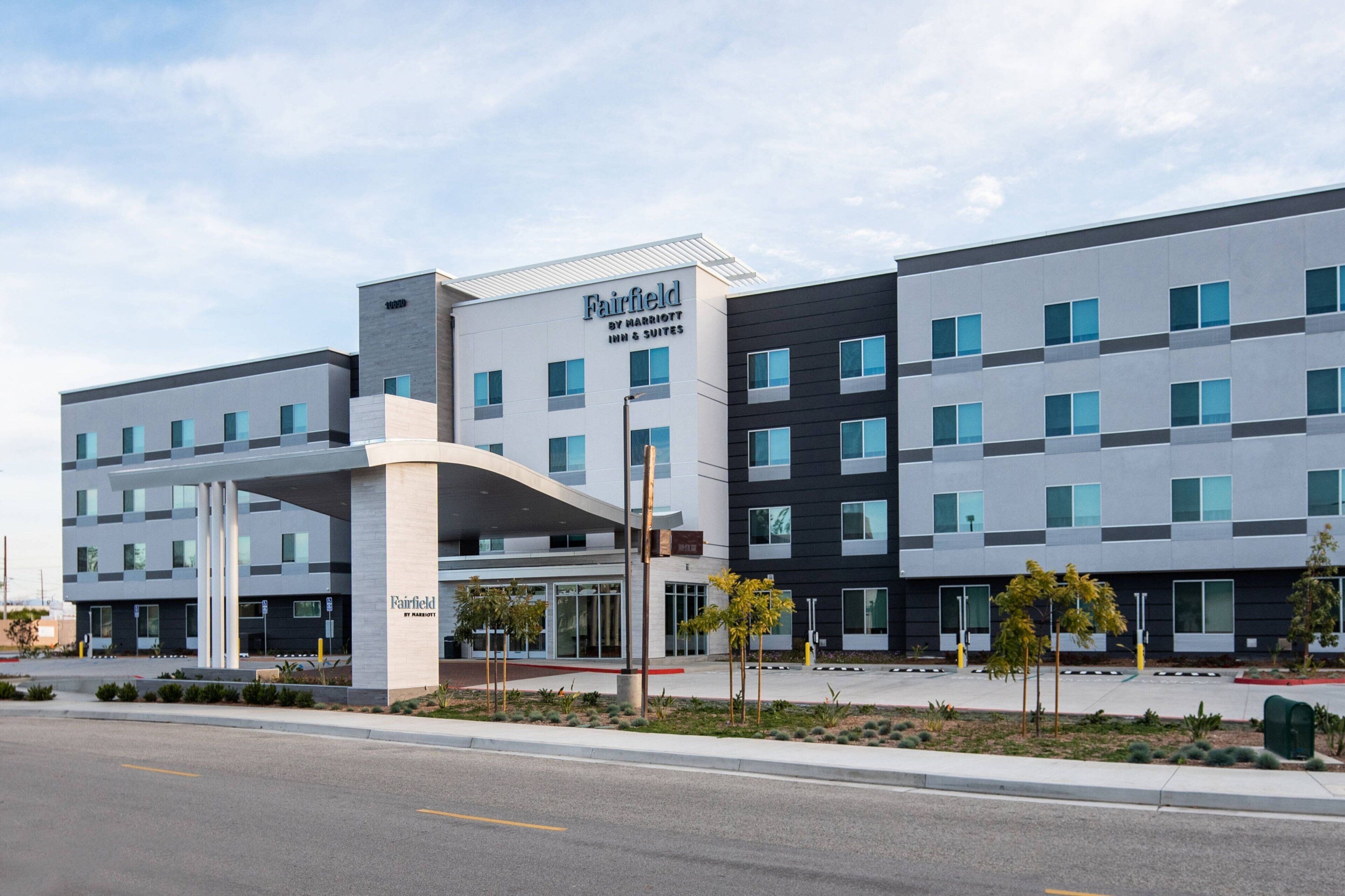 A multi-story hotel with a modern design, featuring a prominent entrance canopy and a series of windows.