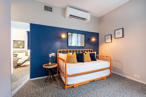 2 habitaciones, escritorio y tabla de planchar con plancha