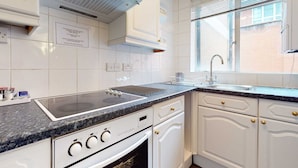 A modern kitchen with white cabinetry, a stainless steel sink, and a built-in oven. - Luxury Serviced Apartment, Staffed Reception, Two Bathrooms, Large Living Room a (London)