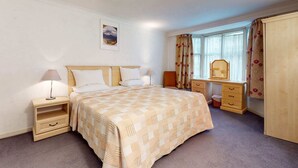 A bedroom with a bed, bedside tables, a dresser, a window with curtains, and a mirror. - Luxury Serviced Apartment, Staffed Reception, Two Bathrooms, Large Living Room a (London)