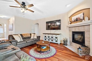Relax in this stylish living room with a leather sofa, flat-screen TV, and cozy fireplace.