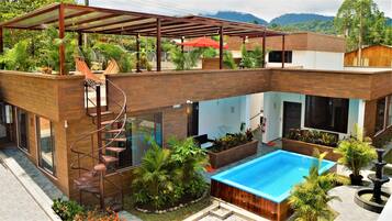 Enjoy an outdoor space with a pool, patio, and garden featuring a small fountain.