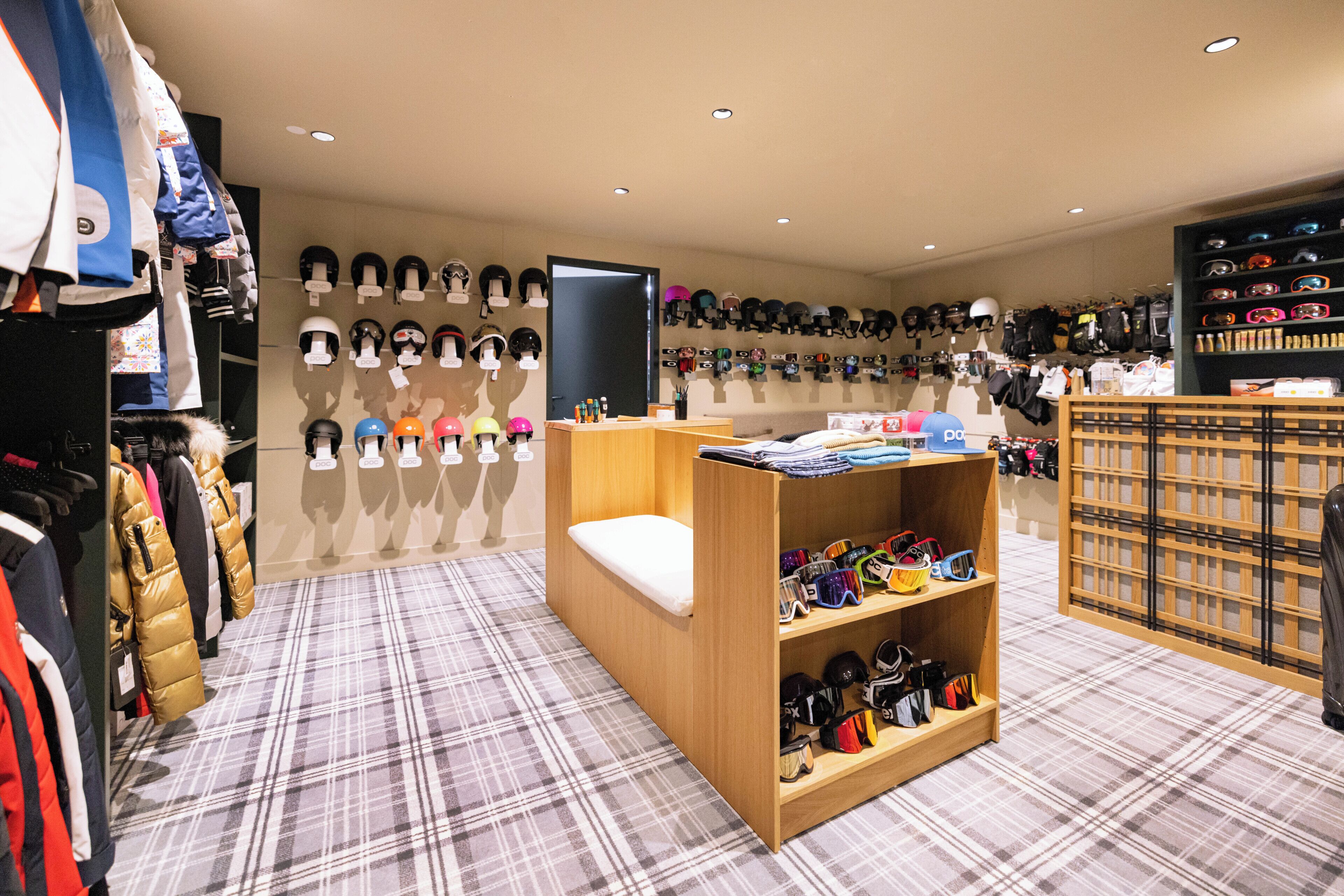 A retail space with a variety of helmets and protective gear displayed on shelves and walls.