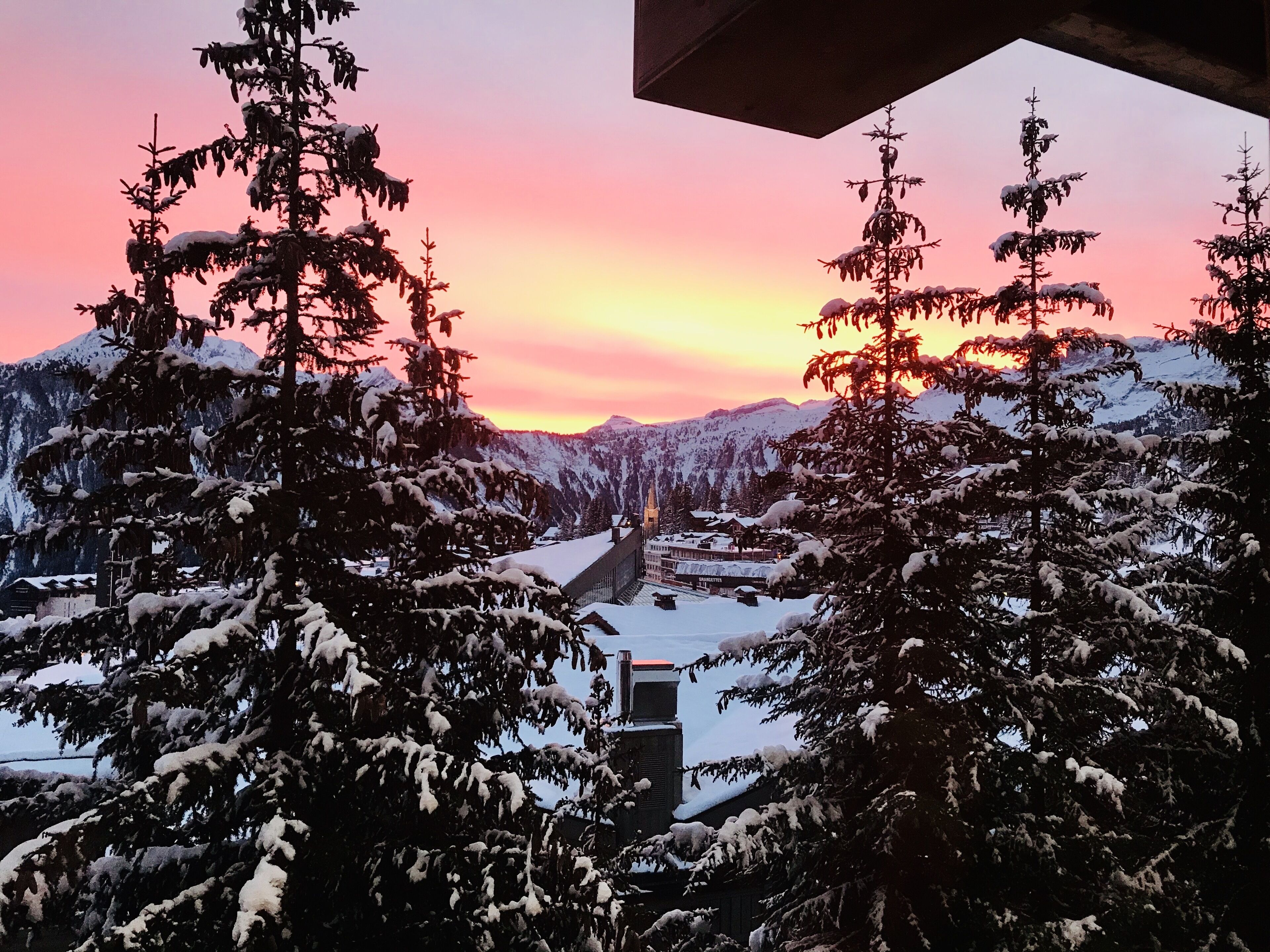 A snowy mountain landscape with a sunset.