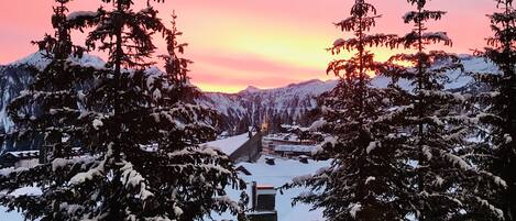 A snowy mountain landscape with a sunset.
