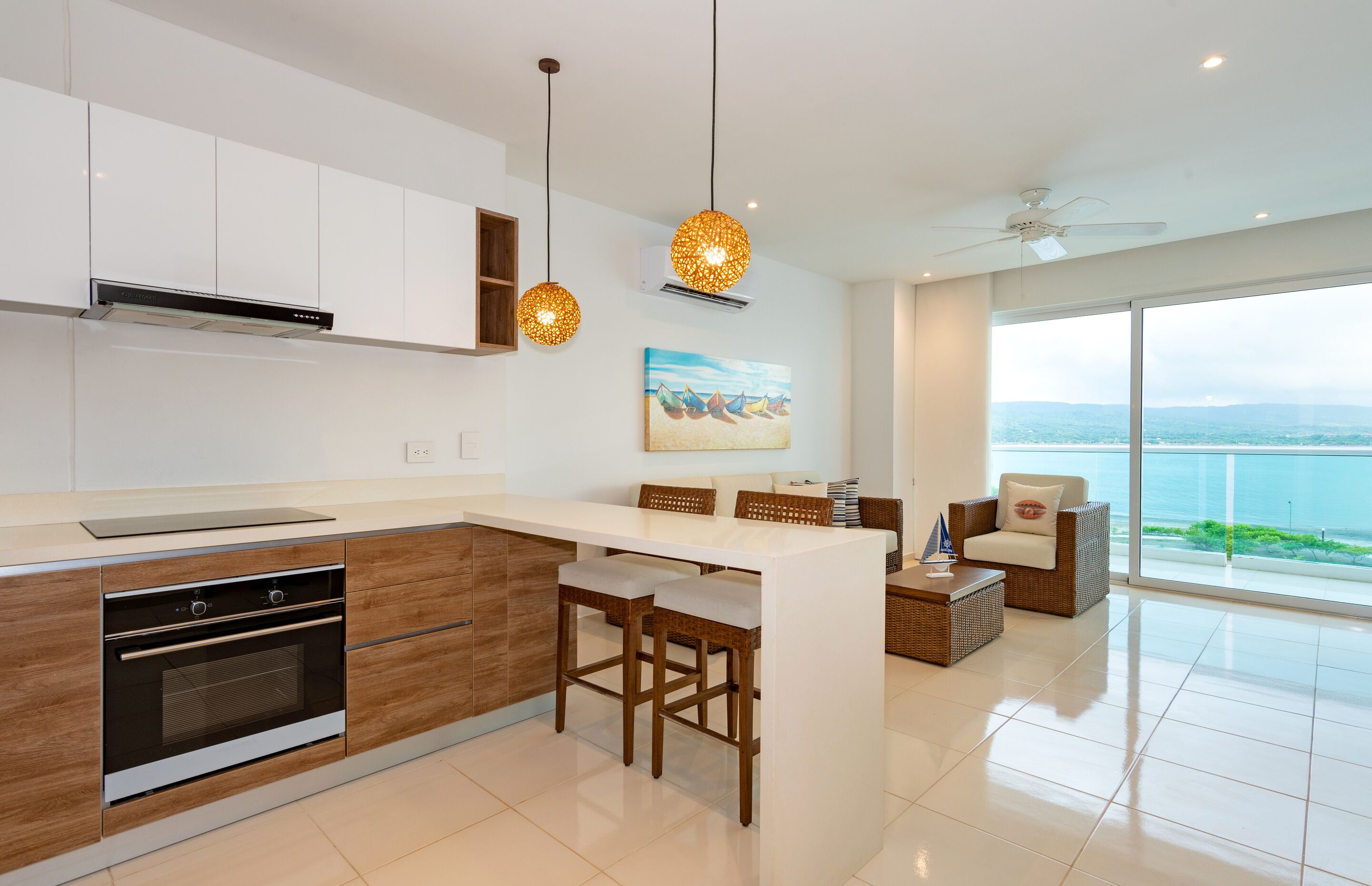 Een moderne keuken met een centraal eiland, houten kastjes en hanglampen.