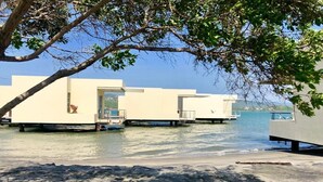 Una propiedad frente al agua con estructuras flotantes, una playa de arena y una vista despejada del agua.