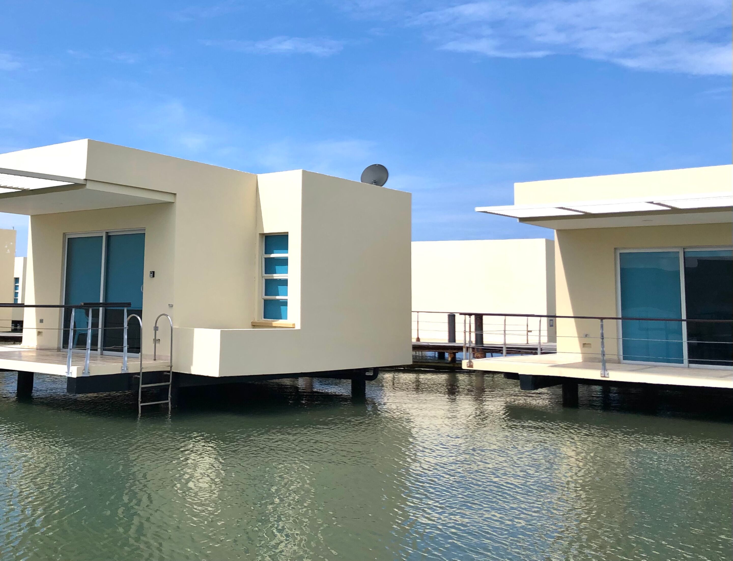 A modern floating structure with a small window, a satellite dish, and a water level indicator.