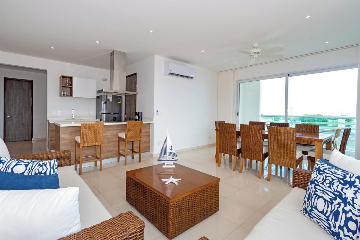 Un espacio habitable moderno con cocina, comedor y un balcón con vistas.