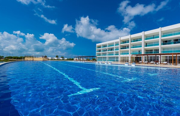 Relax by the large pool surrounded by a multi-story building with spacious balconies.