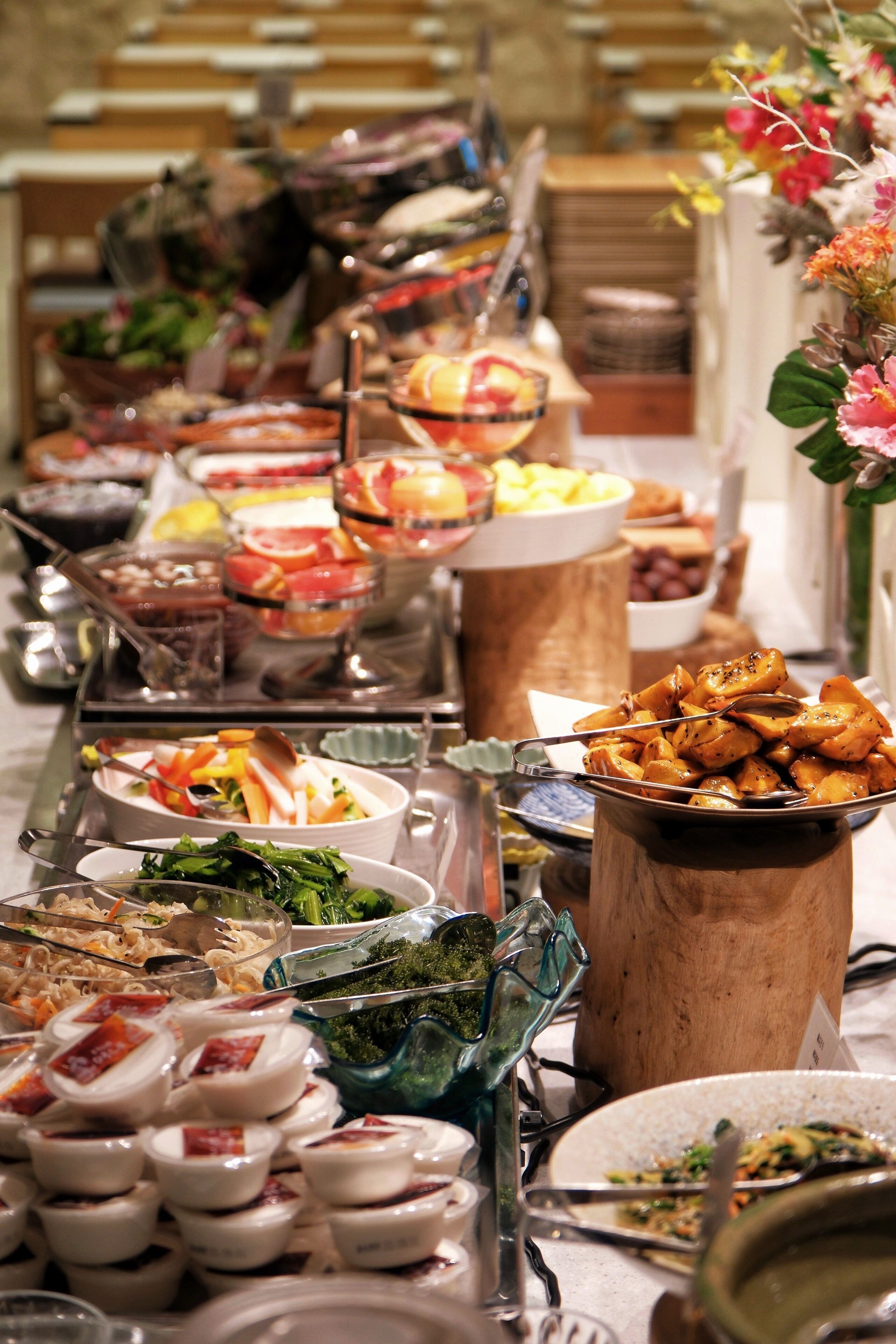 A buffet table with various dishes and food items.